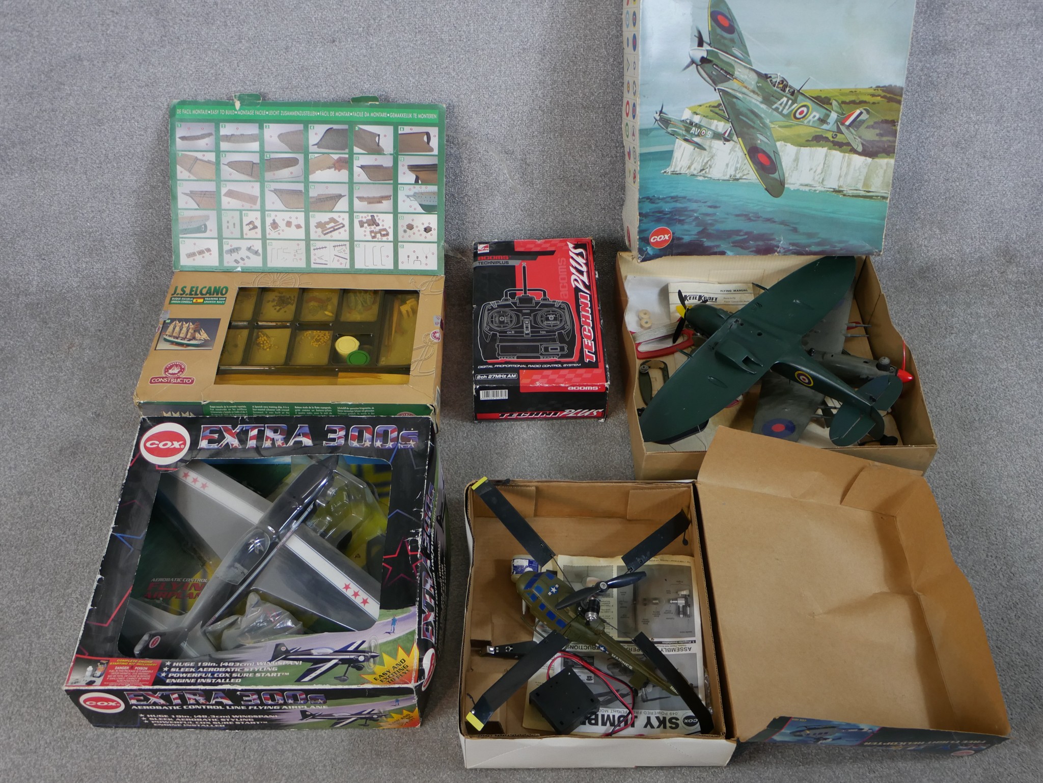 Three boxed model planes including a Cox 300s Extra, a Cox Sky Jumper helicopter and a Cox