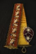 An early 20th century Scandinavian beadwork sash decorated with flowers together with a velvet