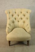 A Victorian style teak framed cream button back low nursing chair raised on turned supports H.89cm.