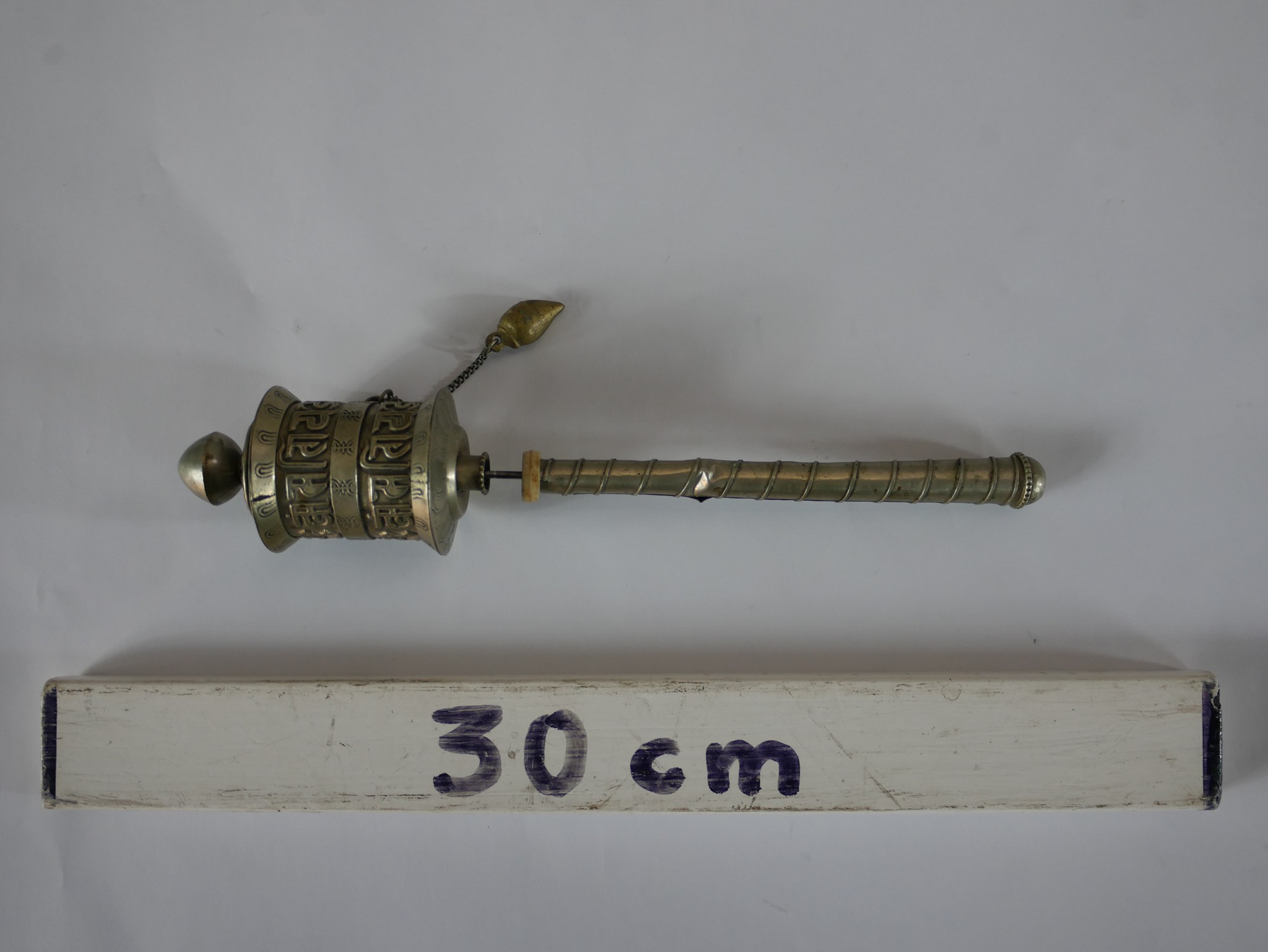 A 20th century polished pewter Tibetan prayer wheel, opening to reveal the original prayer. H.22 W.4 - Image 3 of 3