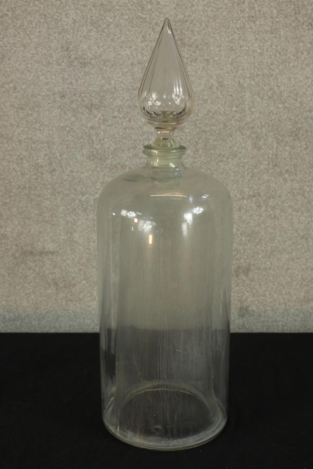 A late 19th/early 20th century clear glass Apothecary jar with teardrop finial. H.65cm.