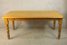 A 20th century stripped pine rectangular kitchen table raised on turned supports. H.77 W.183 D.93cm.
