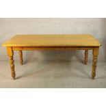 A 20th century stripped pine rectangular kitchen table raised on turned supports. H.77 W.183 D.93cm.