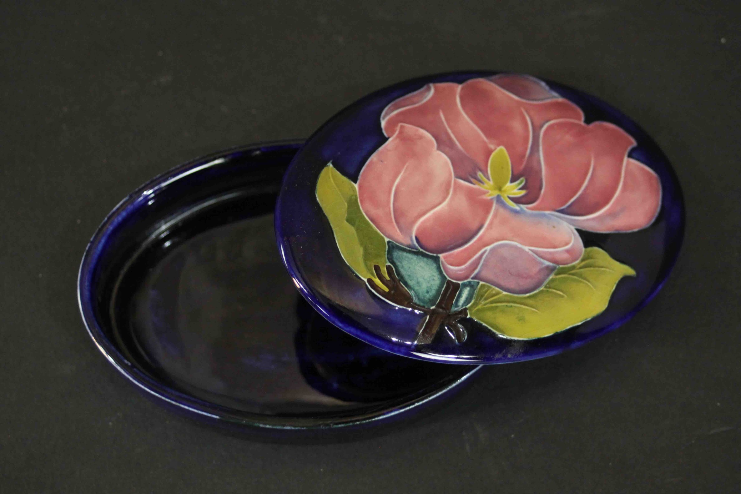 A Moorcroft pink magnolia on blue ground oval powder box. Maker's mark to the base. H.3 W.13cm. - Image 3 of 6