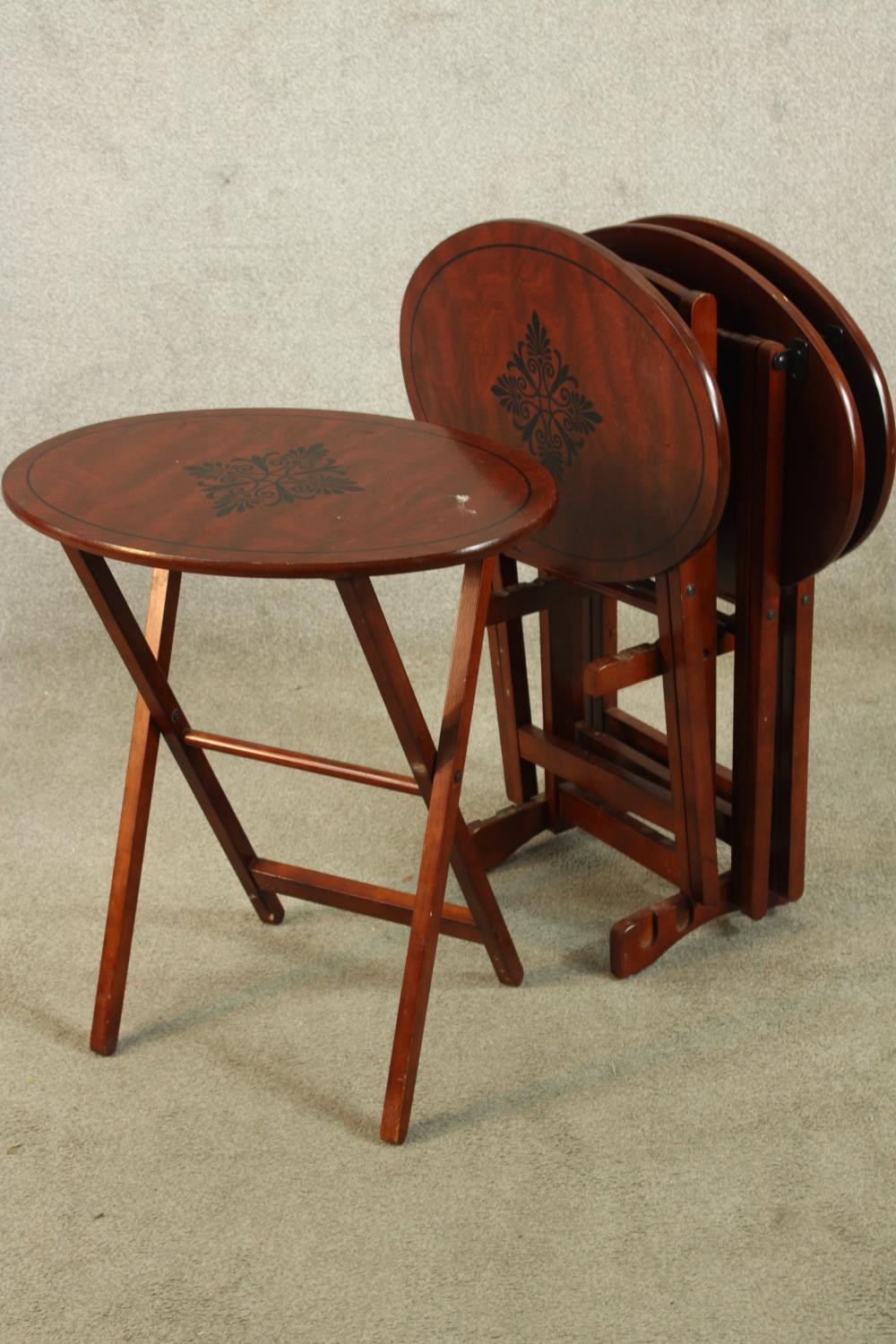 A set of three 20th century mahogany oval topped folding tables with leaf decoration. H.80cm. - Image 3 of 3