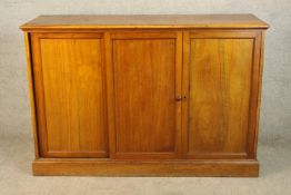 A 19th century mahogany mahogany three door cupboard opening to reveal shelf fitted interior