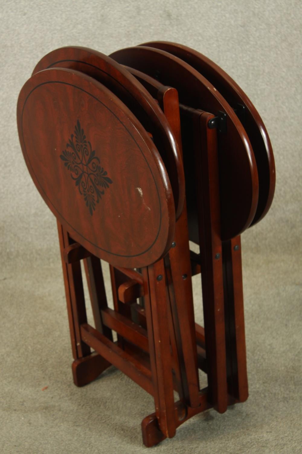 A set of three 20th century mahogany oval topped folding tables with leaf decoration. H.80cm. - Image 2 of 3