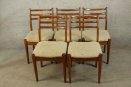A set of five mid 20th century Danish teak framed ladderback dining chairs with drop in