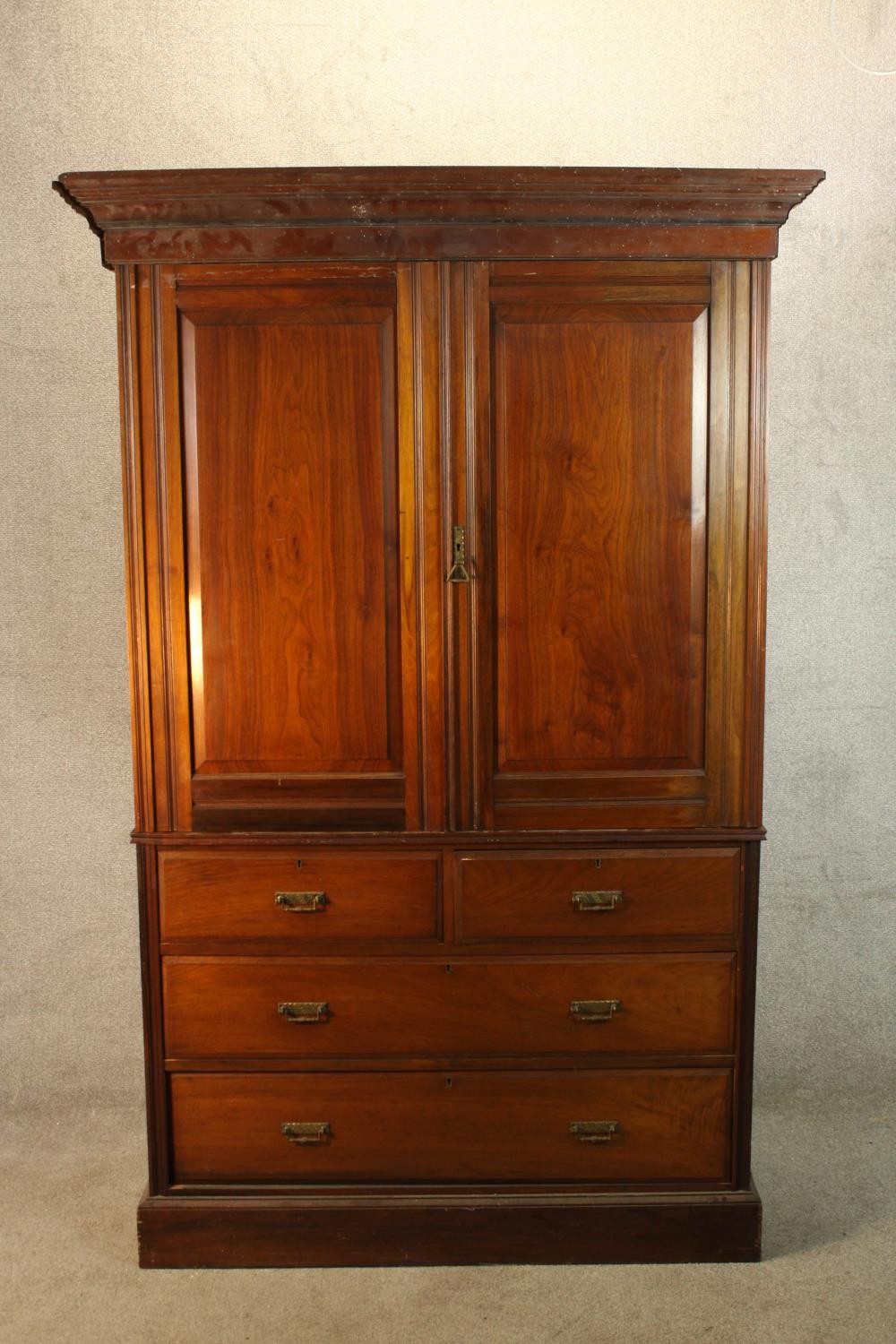 A 19th century mahogany twin door linen press opening to reveal three slides raised on two short