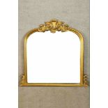 A 20th century Italian style gilt overmantel arch topped overmantel mirror with carved decoration.