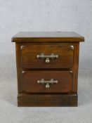 A contemporary stained teak two drawer bedside cabinet raised on plinth base. H.56 W.53 D.43cm