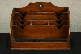 An early 20th century mahogany desktop stationery rack raised on plinth base. H.21 W.31cm.