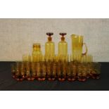 A large collection of mid 20th century amber coloured drinking glasses together with a similar