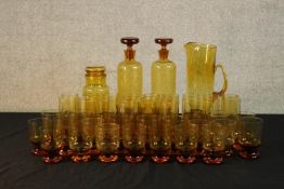 A large collection of mid 20th century amber coloured drinking glasses together with a similar