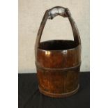 An early 20th century stained oak coopered wooden bucket with carrying handle. H.58cm.