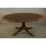 A Georgian style mahogany and satinwood crossbanded oval tilt top breakfast table, the central