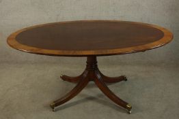 A Georgian style mahogany and satinwood crossbanded oval tilt top breakfast table, the central