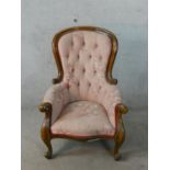 A 19th century mahogany framed spoonback armchair in deep buttoned pink upholstery raised on