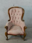 A 19th century mahogany framed spoonback armchair in deep buttoned pink upholstery raised on