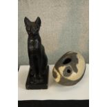 A contemporary black painted plaster figure a seated cat, together with a painted stone modernist