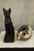 A contemporary black painted plaster figure a seated cat, together with a painted stone modernist