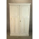 A 1930s white painted oak twin door gentlemen's wardrobe opening to reveal fitted interior raised on