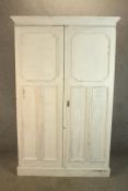 A 1930s white painted oak twin door gentlemen's wardrobe opening to reveal fitted interior raised on