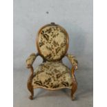 A 19th century carved mahogany framed upholstered armchair raised on carved cabriole supports and