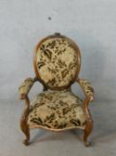 A 19th century carved mahogany framed upholstered armchair raised on carved cabriole supports and