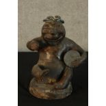 A 20th century Studio pottery figure of a seated man with a drum, with copper lustre finish. H.28cm.