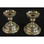 A pair of chrome plated candlesticks, each raised on stepped circular bases. H.13 W.11cm.