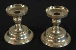 A pair of chrome plated candlesticks, each raised on stepped circular bases. H.13 W.11cm.