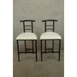 A pair contemporary ebonised bar chairs, possibly after Rodney Kinsman, with cream upholstered seats