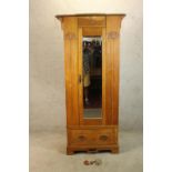 A late 19th century carved walnut single mirror door wardrobe with single drawer raised on shaped