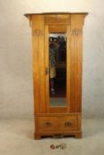 A late 19th century carved walnut single mirror door wardrobe with single drawer raised on shaped