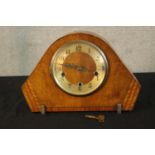 An Art Deco walnut cased mantle clock raised on shaped metal supports. H.23cm.