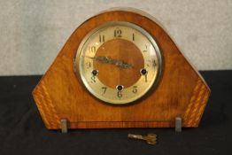 An Art Deco walnut cased mantle clock raised on shaped metal supports. H.23cm.