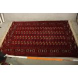 An early 20th century Persian woollen rug with allover gul motifs on a burgundy field. L.280 W.