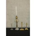 Two 19th century brass candlesticks, together with a silver plated oil lamp base with clear glass