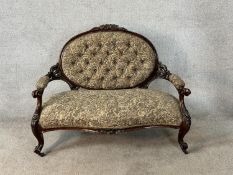 A 19th century mahogany framed open arm settee in deep buttoned floral upholstery raised on carved
