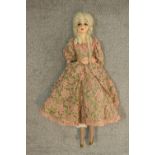 A 19th century clothed female doll with articulated limbs. H.75cm.