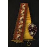 An early 20th century Scandinavian beadwork sash decorated with flowers together with a velvet