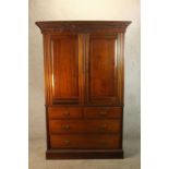 A 19th century mahogany twin door linen press opening to reveal three slides raised on two short