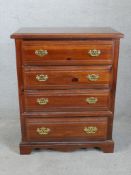 A contemporary Broyhill chest of four long drawers with brass swing handles raised on shaped bracket