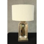A contemporary silver painted octagonal shaped table lamp inset with mirror raised on rectangular