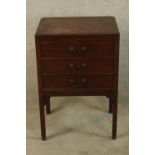 A 19th century mahogany bedside chest of three short drawers with brass swing handles raised on