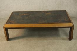 A mid 20th century teak framed coffee table raised on rectangular supports. H.38 W.133 D.74cm.