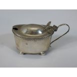 A 19th century hallmarked silver drum mustard (hallmarks worn) with 'S' scroll handle and cast thumb