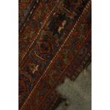 An early 20th century Persian carpet with central sapphire medallion on a burgundy field with