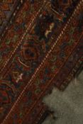 An early 20th century Persian carpet with central sapphire medallion on a burgundy field with